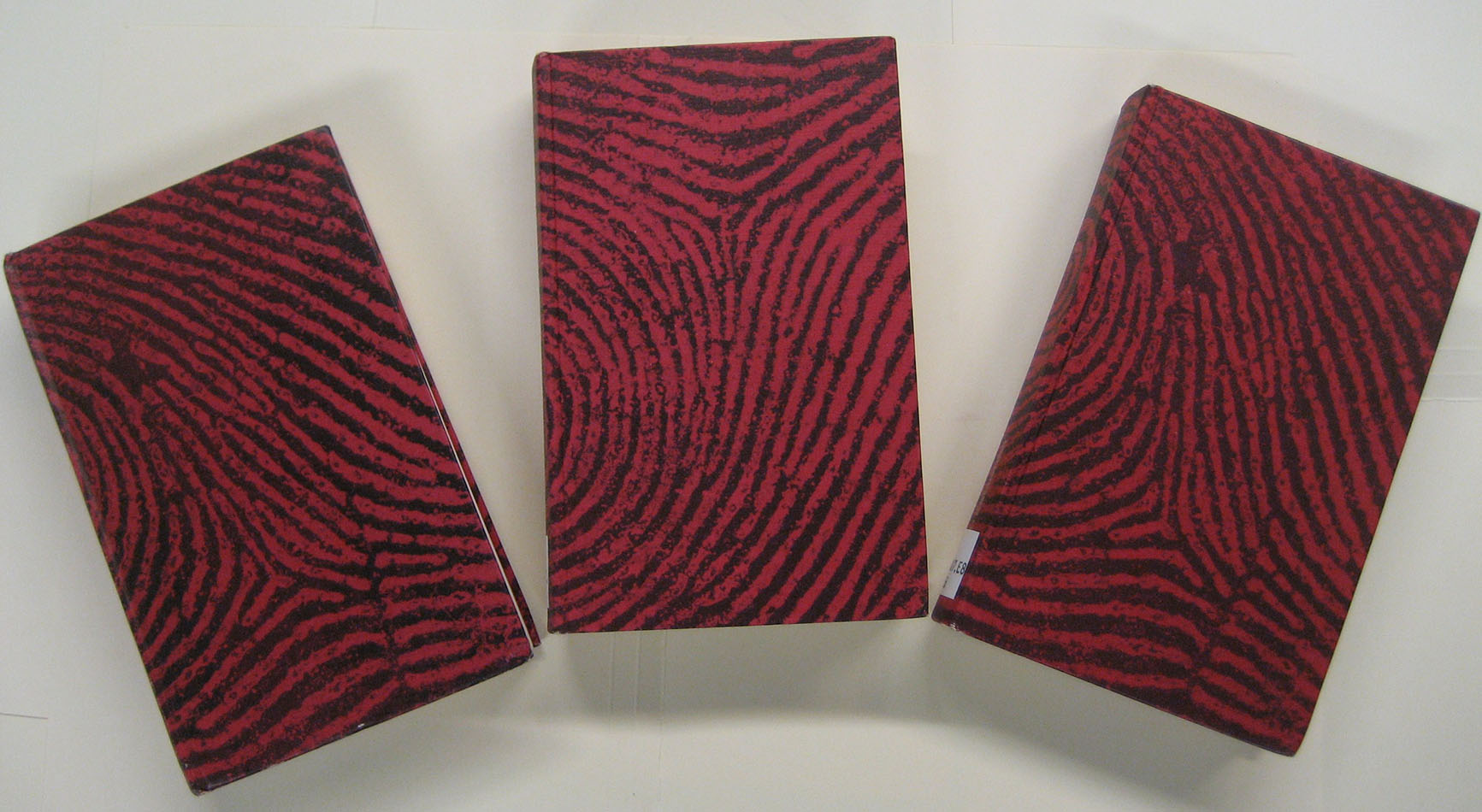 The distinctive black and red enlarged-fingerprint cover designs of the Tête-bêche volumes in the Gebers Dubbeldeckare series. Those pictured are StA PR6007.E8D4B, StA PR6007.E8D423B, and StA PR6007.E8F5B.
