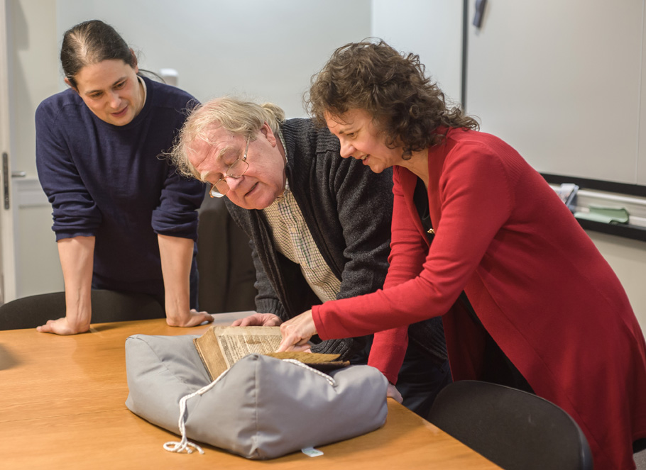 Faculty from the School of English inspect the 1634 Malory at an acquisitions event