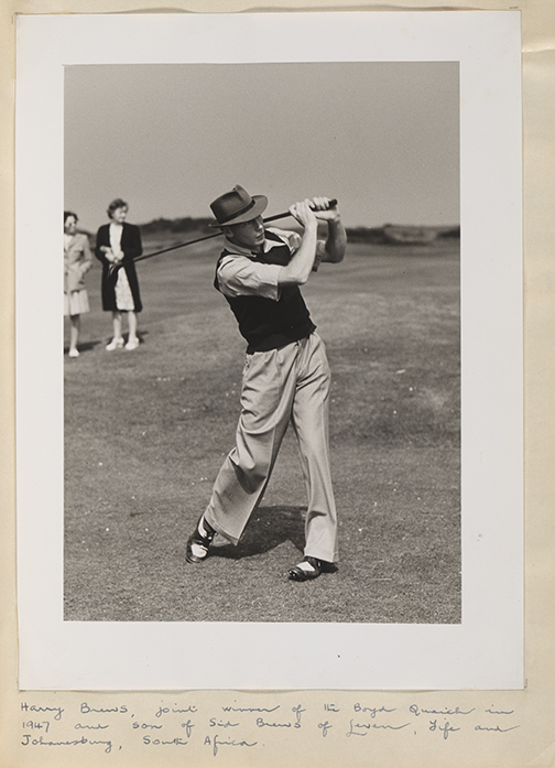 Black and white image of a person mid swing with golf club. Two people are standing in the background.