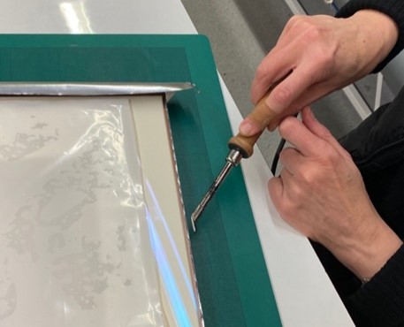 Colour image of frame being sealed with heat spatula 