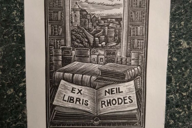 An etching of an open book reading 'Ex libris Neil Rhodes'
