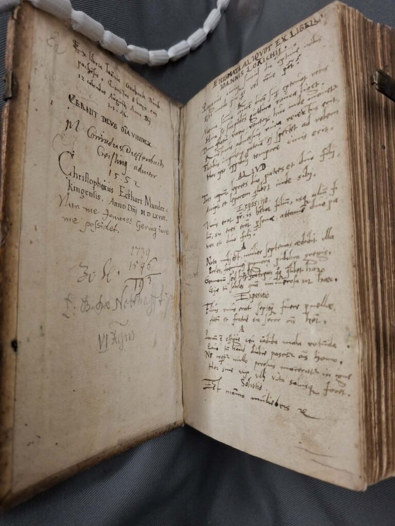 Image of open book with handwritten text in different fonts and languages