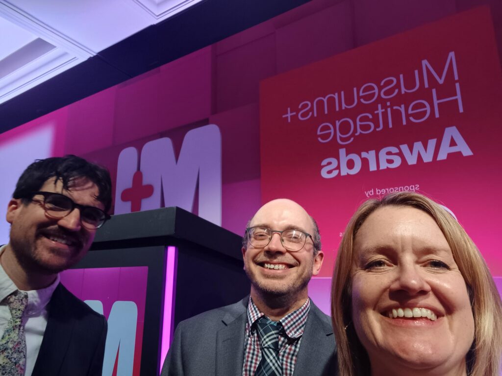 A selfie with three people smiling at the camera.